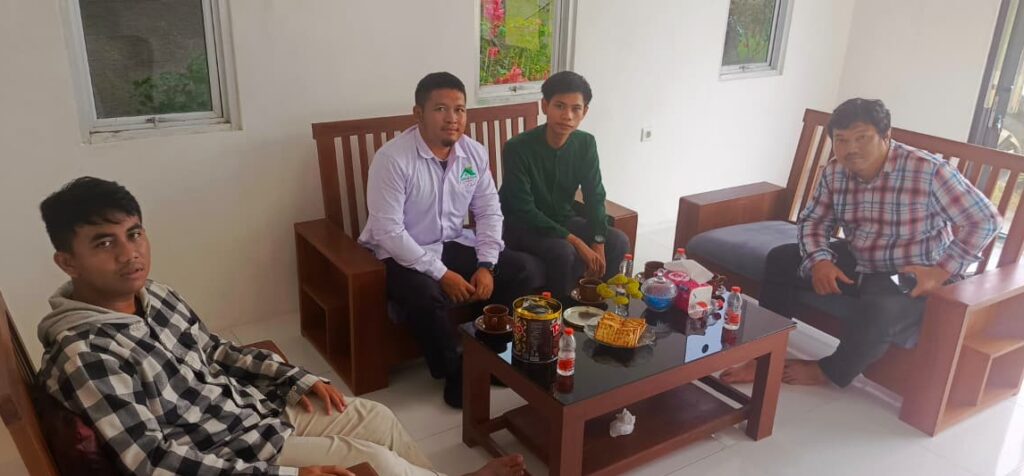 Ilustrasi dua orang bersalaman dalam suasana hangat, melambangkan pentingnya silaturahmi sebagai pembuka pintu rezeki dan keberkahan.