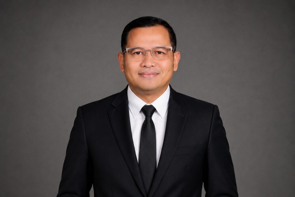 Seorang ayah dan ibu sedang memandang anak-anaknya belajar di rumah sederhana dengan penuh harapan, menggambarkan perjuangan keluarga dan makna syukur yang diwujudkan melalui ikhtiar.